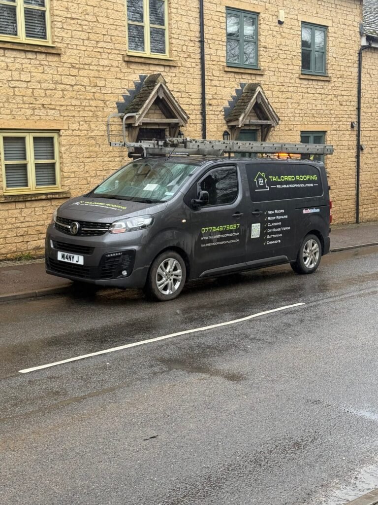Tailored Roofing van parked outside a stone building